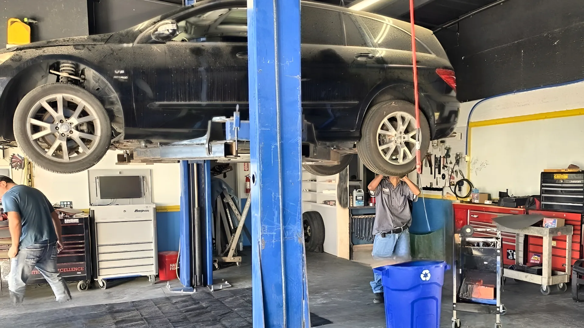A vehicle raised on the two-post lift inside the Servall Mechanics shop.